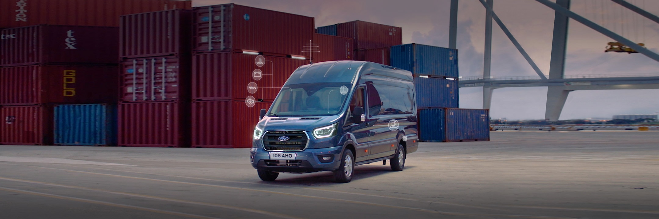 Blue Ford Transit by shipping containers